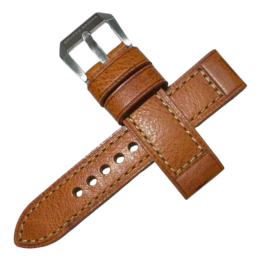 Brown leather watch strap with silver buckle on a white background