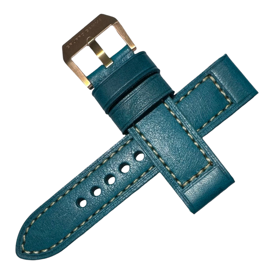 Teal leather watch strap with gold buckle on a white background