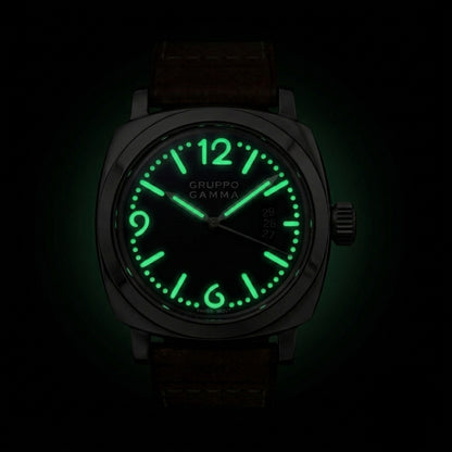 A wristwatch with a dark gunmetal case, a brown leather strap, and a glowing green luminescent dial and hour markers, shown against a pitch-black background.