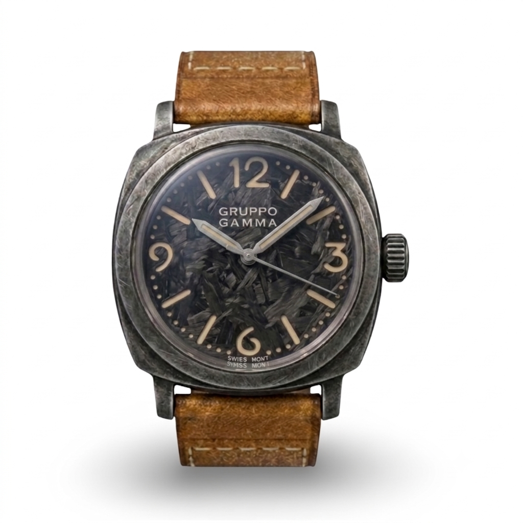 A Gruppo Gamma wristwatch with a distressed dark gray metal case, a lume-infused forged carbon dial with beige Arabic numerals, and a brown leather strap.