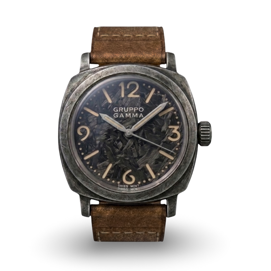 A Gruppo Gamma wristwatch with a distressed dark gray metal case, a lume-infused forged carbon dial with beige Arabic numerals, and a brown leather strap.