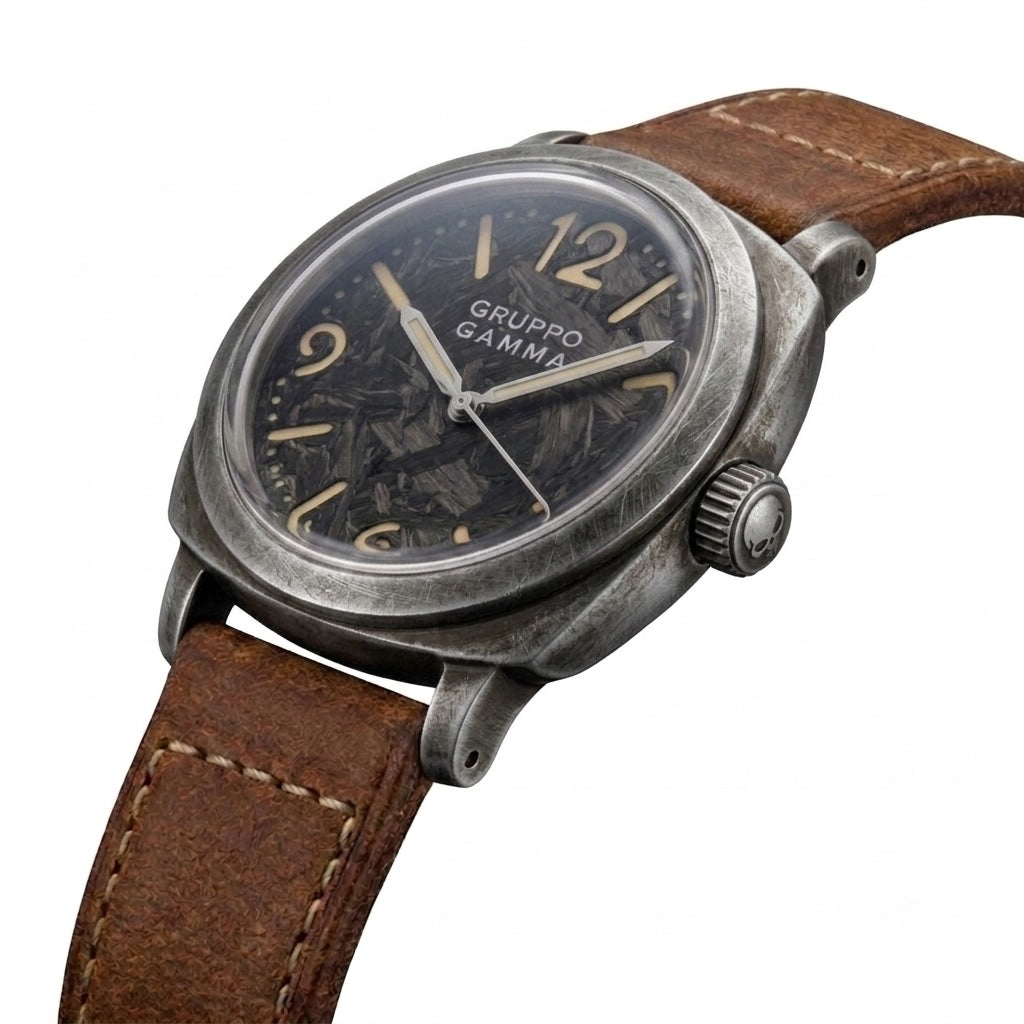 A vintage-style Gruppo Gamma wristwatch with a aged and distressed grey metal case, lumed forged carbon dial, and brown leather strap.