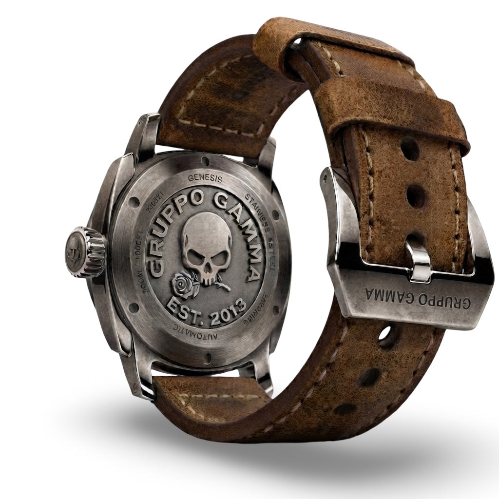 Rear view of a Gruppo Gamma wristwatch with a brushed steel case and brown leather strap, featuring an engraved skull and rose logo on the back.