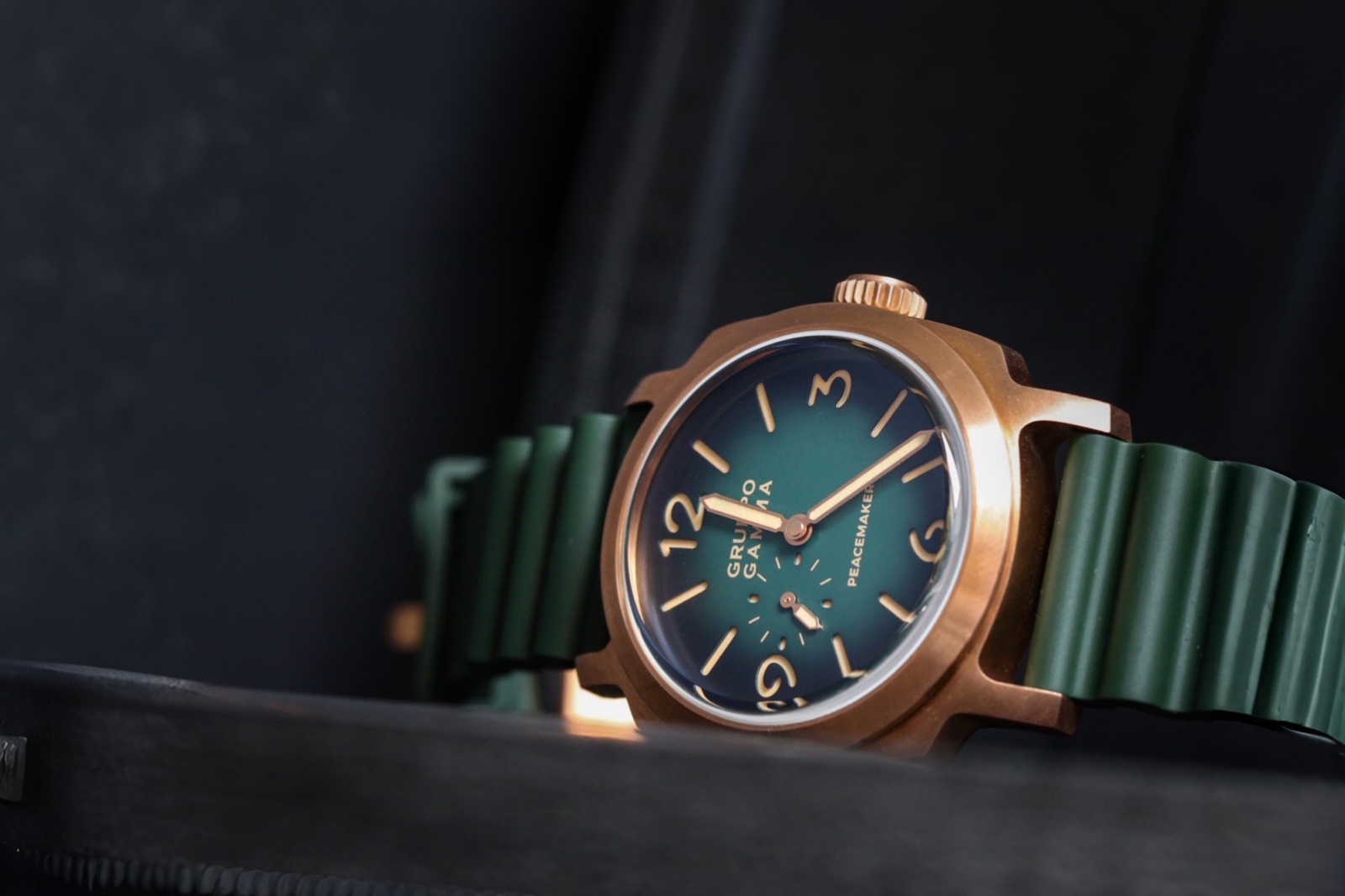 Watch with green strap and blue face on a dark background