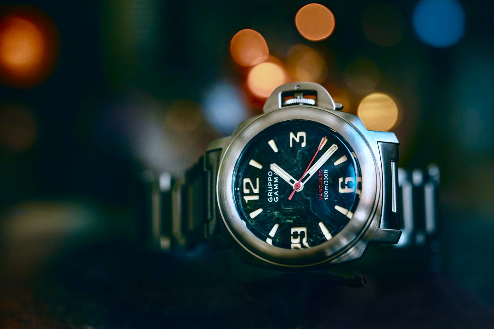 Watch with a dark face and silver case on a blurred background